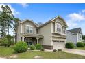 Inviting home with stone-accented porch, lush landscaping, and a two-car garage at 852 Micahs N Way, Spring Lake, NC 28390