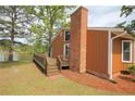 Back exterior of home with brick chimney, deck, overlooking a scenic lake at 104 Cove Landing, Sanford, NC 27332