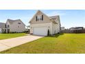 Side view of a two-story home, two-car garage with a spacious, well-maintained lawn at 110 Wynngate Dr, Cameron, NC 28326