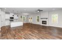 Open-concept living space with a fireplace, hardwood floors, a modern kitchen, and lots of natural light at 186 N Ashe Ave, Dunn, NC 28334
