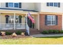 Inviting front porch with American flag, brick accents, and neatly landscaped flower bed at 106 Polk St, Spring Lake, NC 28390