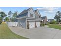 Exterior side view showing the driveway, fenced yard, and three-car garage at 12 Ballentyne Ct, Sanford, NC 27332