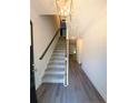Inviting home entryway featuring stylish flooring, a staircase, and contemporary lighting at 121 Camille Brooks Dr, Angier, NC 27501