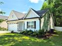 Attractive home exterior with a two-car garage, complemented by lush greenery and partial shade at 121 Camille Brooks Dr, Angier, NC 27501