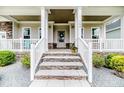 Inviting front porch with stone steps, white railings, and a view of the home's exterior at 152 Education Dr, Spring Lake, NC 28390