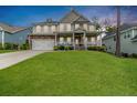 Beautiful two-story home with a lush green lawn, inviting front porch, and attached two-car garage at 152 Education Dr, Spring Lake, NC 28390