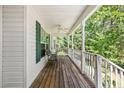 Inviting covered front porch featuring a ceiling fan, ample seating, and beautiful outdoor views at 46 Sherwood Hills Ct, Cameron, NC 28326