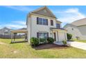 Charming two-story home featuring a manicured lawn, attached garage, and backyard carport at 104 Red Coat Dr, Cameron, NC 28326