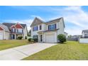 Charming two-story home featuring a manicured lawn, attached garage and long driveway at 104 Red Coat Dr, Cameron, NC 28326
