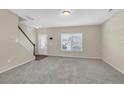 Spacious living room featuring new carpet, a large window, and a staircase at 104 Red Coat Dr, Cameron, NC 28326