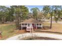 Aerial view of single-story home with front porch, white trim, and a long, curved driveway at 201 Sierra Trl, Spring Lake, NC 28390