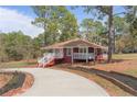 Single-story home with a red facade, white trim, a front porch, and a curved driveway at 201 Sierra Trl, Spring Lake, NC 28390