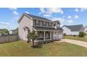 Traditional two-story home featuring a welcoming front porch, well-manicured lawn, and a two-car garage at 352 Asheford Way, Cameron, NC 28326