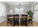 Formal dining room with wainscoting, wood floors, and a stylish chandelier for elegant meals at 74 Spruce Hollow Cir, Spring Lake, NC 28390