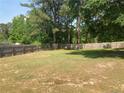 Spacious backyard enclosed by a wooden fence and surrounded by mature trees, offering privacy at 109 Rock Harbor Ln, Spring Lake, NC 28390