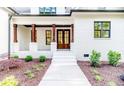 Home featuring dark wood columns, brick facade, landscaped yard, and an inviting front entrance at 134 Zion Church Rd, Sanford, NC 27332