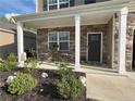 Inviting front porch with stone accents, seating, and landscaping that enhances the curb appeal at 158 David Hill Dr, Sanford, NC 27330