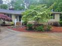 Inviting home exterior featuring a landscaped front yard with a flowering dogwood tree and a brick-lined walkway to the front door at 179A Fairway Ln, Sanford, NC 27332