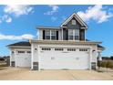 Three-car garage featuring white doors and stone accents, enhancing curb appeal and functionality at 1968 Josey Williams Road, Erwin, NC 28339