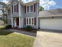 Home exterior featuring gray siding, red shutters, and an attached garage at 23 Glenn Oak Dr, Sanford, NC 27330
