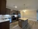 A modern kitchen with granite countertops, stainless steel appliances, and a center island at 240 Gallery Dr # 203, Spring Lake, NC 28390
