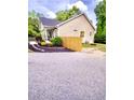 View of the home exterior featuring a wooden fence and stone-lined landscaping at 303 Tanglewood Dr, Louisburg, NC 27549