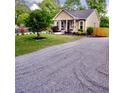 Inviting single-story home showcasing well-maintained landscaping and a stone driveway at 303 Tanglewood Dr, Louisburg, NC 27549