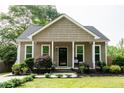 Beautifully landscaped front yard showcasing a charming home with a welcoming porch at 303 Tanglewood Dr, Louisburg, NC 27549