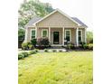 Inviting home featuring a cozy front porch, well-kept lawn, and professional landscaping at 303 Tanglewood Dr, Louisburg, NC 27549
