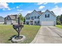 Two-story home with blue siding, well-kept lawn, and a driveway leading to a two-car garage at 101 Shepard Dr, Linden, NC 28356
