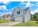 Two-story home with light blue siding, black shutters, and an attached two-car garage at 101 Shepard Dr, Linden, NC 28356