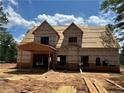 Exterior view of new home construction, showcasing the framed garage and sheathed exterior with wooded surrounding at 194 Landon Rdg, Sanford, NC 27330