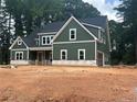 Angle view of two-story home featuring vertical siding, a dark roof, white trim, and traditional windows at 194 Landon Rdg, Sanford, NC 27330