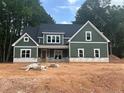 New two-story home featuring vertical siding, a dark roof, white trim, and traditional windows at 194 Landon Rdg, Sanford, NC 27330