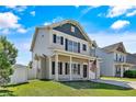 Beautiful two-story home with a covered porch, black shutters, and an American flag at 21 Bicentennial Way, Cameron, NC 28326