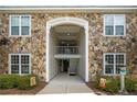 Exterior stone-covered entrance to a residential building with well-kept landscaping at 310 Gallery Dr # 201, Spring Lake, NC 28390