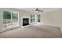 Cozy living room with a fireplace, neutral carpeting, and large windows offering ample light at 569 Yorkshire Dr, Cameron, NC 28326