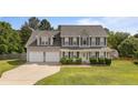 Traditional two-story home with gray siding, black shutters, well-maintained lawn, and two-car garage at 11 Checkmate Ct, Cameron, NC 28326