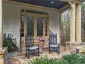 Covered porch featuring flagstone flooring, two rocking chairs, a small table, and metal railings at 20017 Bragg, Chapel Hill, NC 27517
