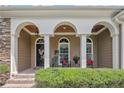 Inviting front porch with brick steps, arched columns, and comfortable seating for relaxing at 42 Skipping Water Dr, Spring Lake, NC 28390