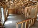 Unfinished interior showcasing exposed framing, soaring ceilings, and ample natural light at 53 Horse Trot Ln, Sanford, NC 27332