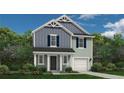 Charming two-story home with a blend of blue and green siding, front porch, and attached garage at 598 Blossom Trl, Lillington, NC 27546