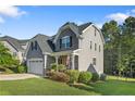 Attractive gray home with manicured lawn and stone accents on a sunny day at 102 Scholar Dr, Spring Lake, NC 28390
