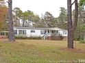 Single story home with a covered porch and surrounded by large trees at 104 Beacon Ln, Cameron, NC 28326