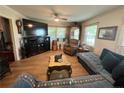 Comfortable living room with a large TV, wooden floors, neutral paint, and ceiling fan at 12558 Mcdougald Rd, Broadway, NC 27505