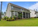 Green backyard features a screened-in porch, mature landscaping and a well-maintained lawn at 22 Education Dr, Spring Lake, NC 28390