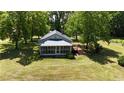Charming home with a metal roof, screened porch, and wooden deck surrounded by a lush lawn at 3997 Swanns Station Rd, Sanford, NC 27332