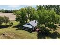 Aerial view of the house, featuring a screened front porch, wooden deck, surrounded by mature trees at 3997 Swanns Station Rd, Sanford, NC 27332