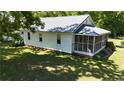 Side view of the house with a metal roof, screened porch and well maintained landscaping at 3997 Swanns Station Rd, Sanford, NC 27332