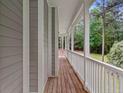 View along the front porch highlighting wood floors, and white trim and railings at 635 Buckroe Dr, Sanford, NC 27330